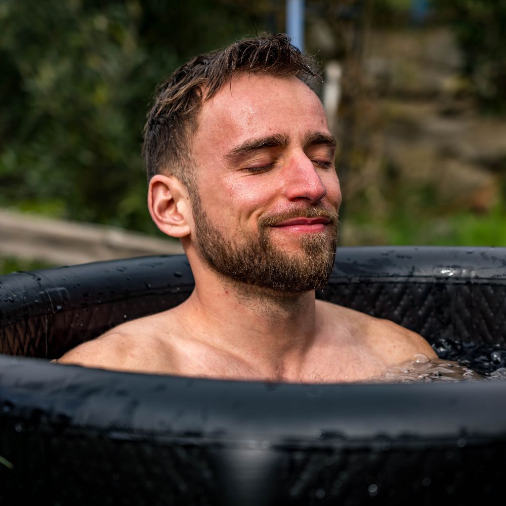 un  homme qui sourit dans un bain froid
